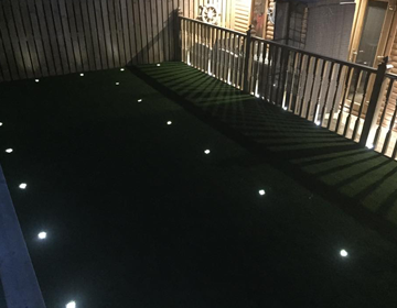 Integrated spotlights in artificial grass at night