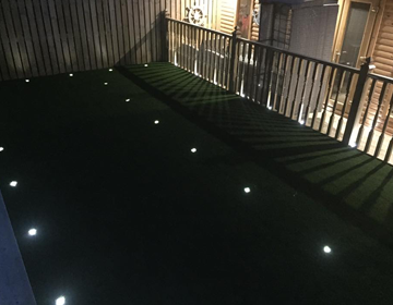 Spotlight integrated into artificial grass at night