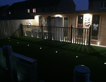 Spotlight integrated into artificial grass at night