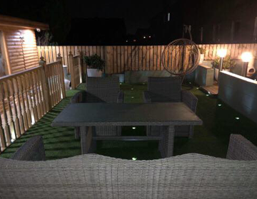 Wicker furniture with spotlights integrated into artificial grass